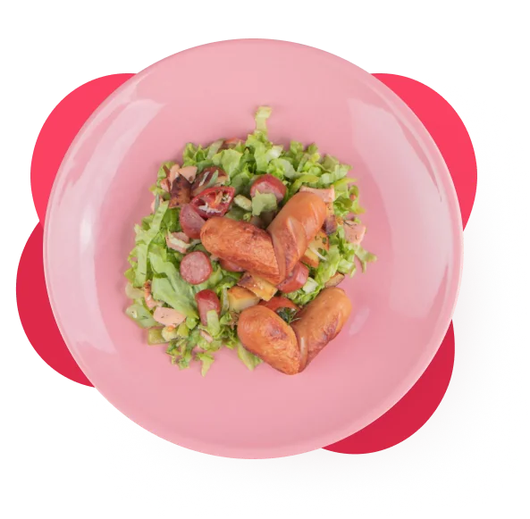 Colorful salad with lettuce, cherry tomatoes, and grilled sausages on a pink plate.