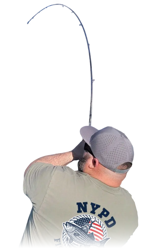 A man fishing in the ocean, reeling in a catch while wearing a NYPD fishing shirt.